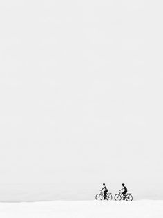 two people riding bikes in the snow