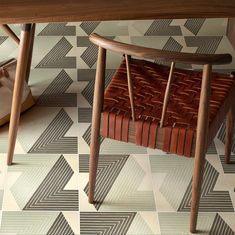 a wooden chair sitting on top of a tiled floor next to a table and shoes