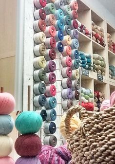 there are many balls of yarn hanging on the wall