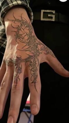 a person with a tattoo on their hand holding up his hand to show the wrist