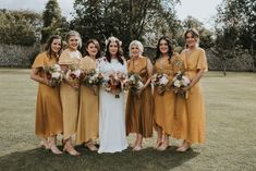 a group of women standing next to each other on top of a lush green field