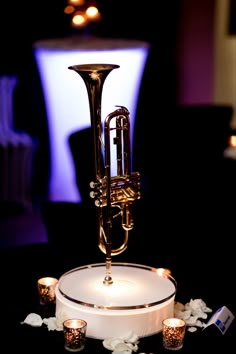 a trumpet sitting on top of a table next to candles