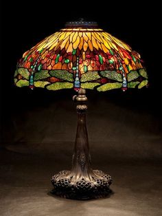 a lamp that is sitting on top of a table with a glass shade over it