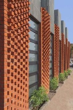 a row of red brick buildings next to each other with plants growing out of them