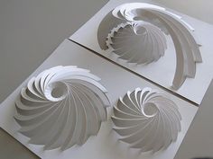 two white paper sculptures sitting on top of a table