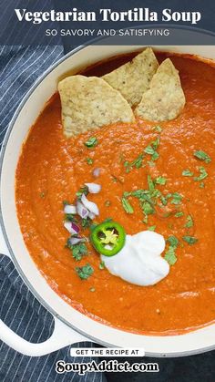 a bowl of soup with tortilla chips and sour cream in the top corner