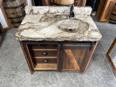 a bathroom sink with marble counter top and wooden cabinet drawers in front of other sinks