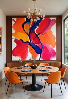 a dining room table with orange chairs and a large painting on the wall