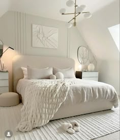 a bedroom with white bedding and pillows