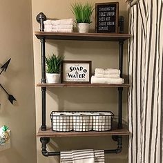 a bathroom with three shelves holding towels and plants