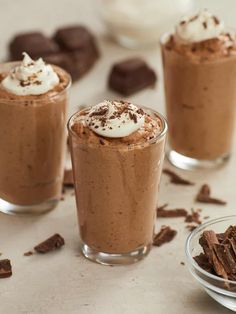 three glasses filled with chocolate pudding and whipped cream