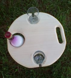 a wine bottle sitting on top of a wooden table next to a glass cup and water