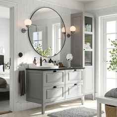 a bathroom with a sink, mirror and bathtub in the middle of the room