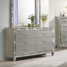 a silver dresser and mirror in a room