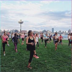 a large group of people doing yoga in the park