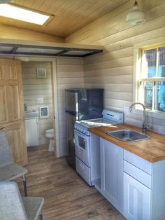 a kitchen area with sink, stove and refrigerator