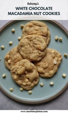 A blue bowl with 5 white chocolate macadamia nut cookies and white chocolate chips spread over it. Text overlay says "Subway's White Chocolate Macadamia Nut Cookies"