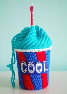 a crocheted cup cozying with a red, white and blue yarn ball