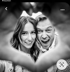 a man and woman are smiling while holding their hands out in front of the camera