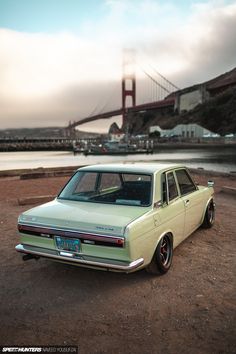 an old car is parked in front of the golden gate bridge