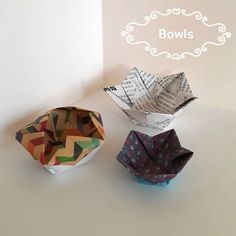 three origami bowls sitting next to each other on top of a white table