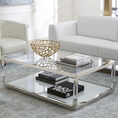 a living room filled with furniture and a glass coffee table on top of a rug