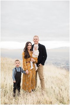 a man and woman with two children standing in tall grass