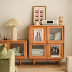 a living room with a green couch and some pictures on the wall next to it