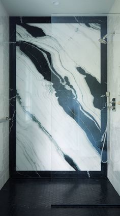 a white and black bathroom with marble walls