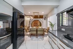 a modern kitchen and dining area with marble counter tops, white walls and flooring