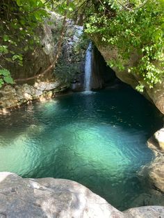 there is a pool in the middle of some rocks