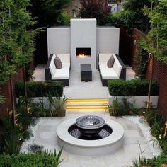 an outdoor fire pit in the middle of a garden with seating and trees around it