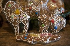 several decorated cookies sitting on top of a wooden table next to a basket filled with candy