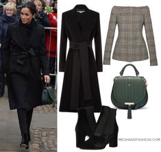 a woman in black coat and boots walking down the street with handbag next to her