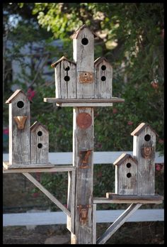 a wooden bird house with several birds on it