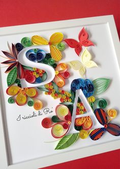 the letter s is made out of paper and decorated with colorful flowers, leaves and butterflies