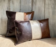 two brown and white pillows sitting next to each other