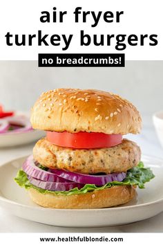 a chicken burger with lettuce, tomato and onion on it in front of the text turkey burgers air fried in 15 minutes