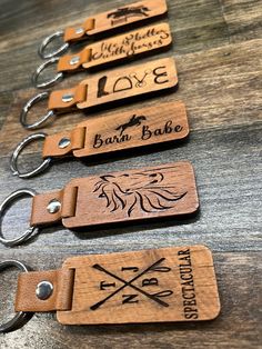 three wooden key chains with engraved labels on them