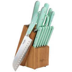 a set of green kitchen knives in a wooden block