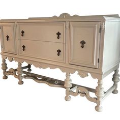 an old dresser is painted white and has ornate carvings on the top, along with two drawers