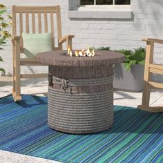 a fire pit sitting on top of a rug next to two rocking chairs