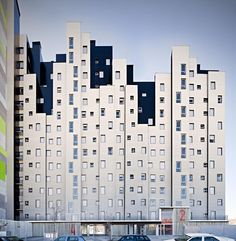 several cars parked in front of a tall building