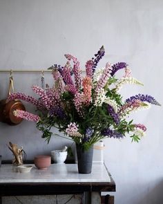 a vase filled with lots of purple and white flowers