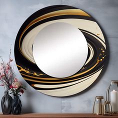 a round mirror sitting on top of a wooden table next to a vase with flowers