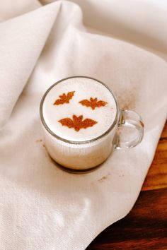 a cup filled with liquid sitting on top of a wooden table next to a napkin