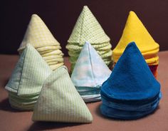 several folded cloths sitting next to each other on top of a brown tablecloth