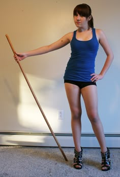 a woman in short shorts is holding a stick