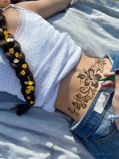 a woman laying on top of a bed covered in sunflowers next to her stomach