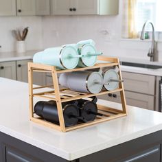 a kitchen island with rolling doughnuts and cups on the tray in front of it